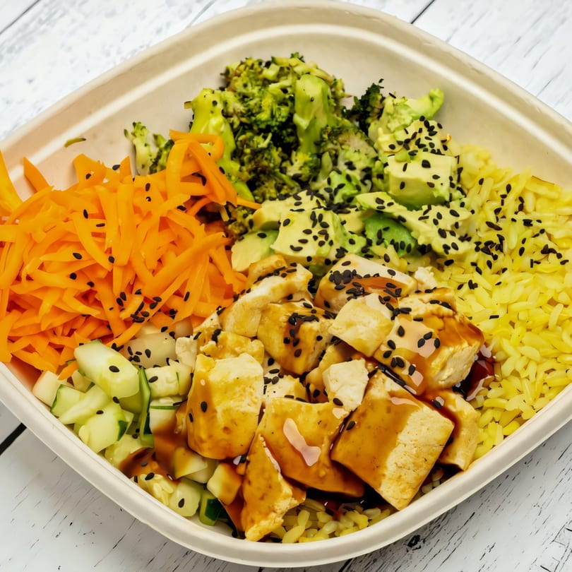 Sprout Mediterranean salad bowl with tofu, broccoli, carrots, avocado, cucumber, and yellow rice.